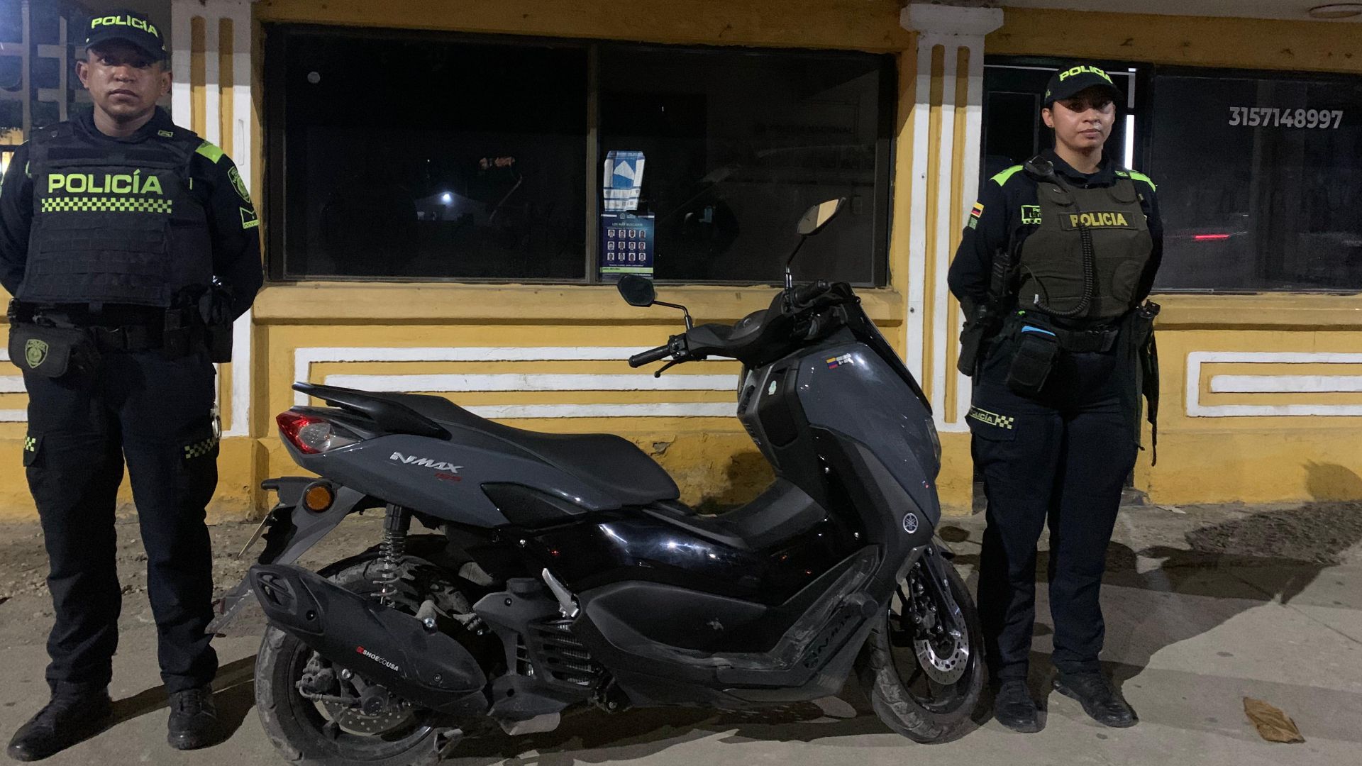 Uniformados de la Policía Metropolitana de Barranquilla con moto hurtada que recuperaron.